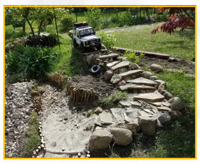 A small 3m x 2m backyard RC crawler course with rocks, pallets and logs