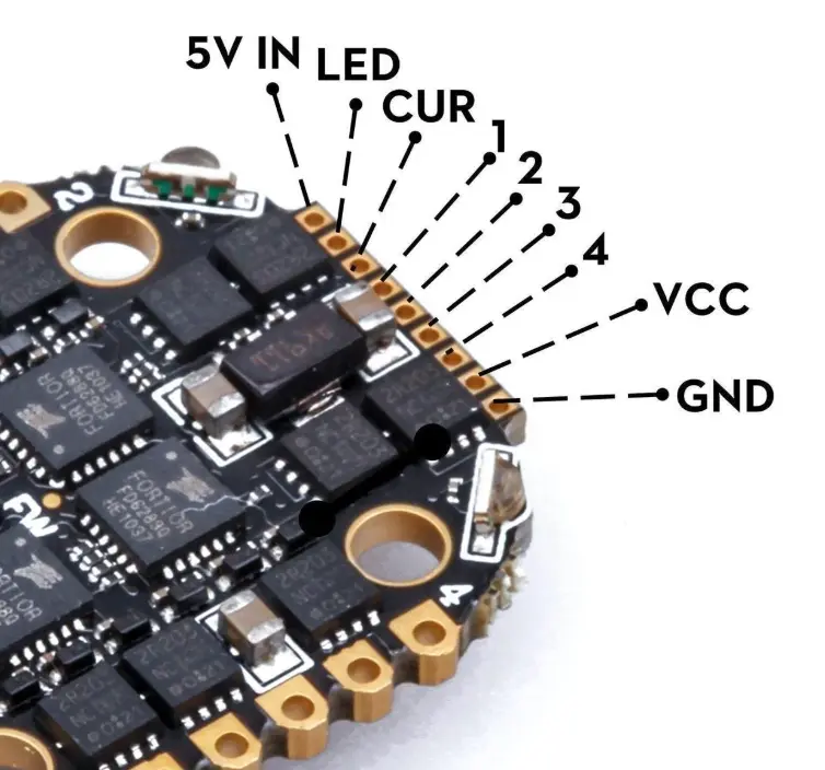 Close-up of FPV drone ESC solder pads and capacitor polarity during a wiring inspection