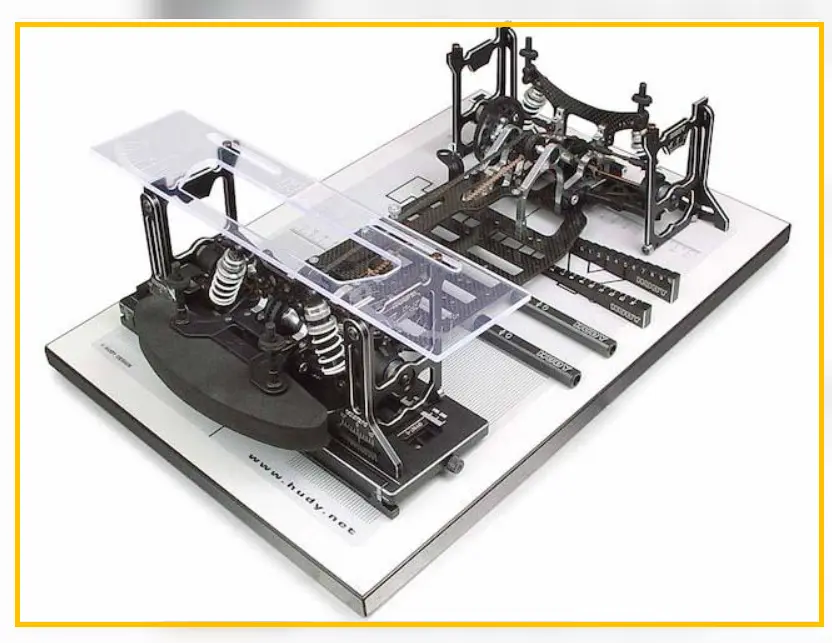 RC touring car chassis on a flat setup board for suspension inspection