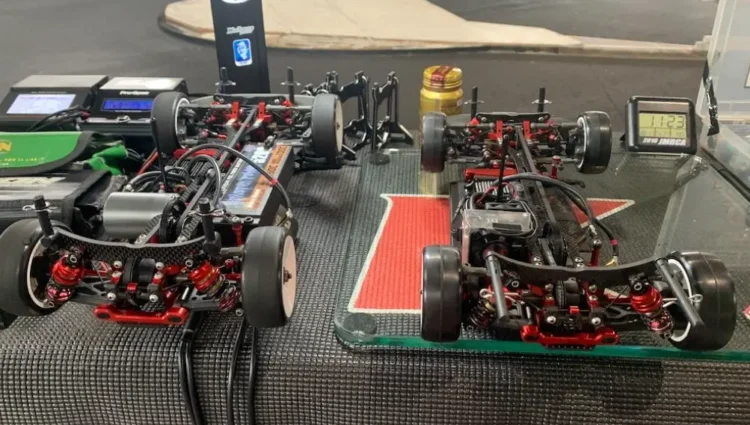 Spare RC touring car tires and setup tools arranged on a racing pit table